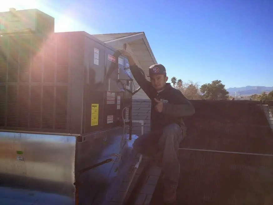HVAC technician performing HVAC Inspection on a rooftop unit in Cedar City